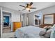 Well-lit bedroom with a ceiling fan, a dresser, a window, and a calming gray color scheme at 2933 White Cedar Cir, Kissimmee, FL 34741