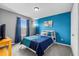 Bright bedroom with a blue accent wall, complemented by a comfortable bed and natural light from the window at 2933 White Cedar Cir, Kissimmee, FL 34741