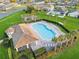 Aerial view of the community pool with palm trees, lounge chairs, and a clubhouse at 2933 White Cedar Cir, Kissimmee, FL 34741