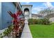 Inviting home exterior featuring a walkway lined with vibrant plants, lush green lawn, and charming facade at 2933 White Cedar Cir, Kissimmee, FL 34741