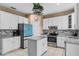 Bright and modern kitchen featuring white cabinets, a center island and stainless steel appliances at 2933 White Cedar Cir, Kissimmee, FL 34741