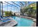 Screened in pool with waterfall feature, lounge chairs, and lush landscaping for a private oasis at 2933 White Cedar Cir, Kissimmee, FL 34741