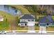 Charming two-story home next to a pond with solar panels and a brick paver driveway at 2984 Sanctuary Dr, Clermont, FL 34714