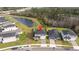 Stunning aerial view of a two-story home with solar panels nestled near a pond and other community houses at 2984 Sanctuary Dr, Clermont, FL 34714