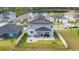 Aerial shot featuring a spacious backyard with a covered patio, stone fire pit, and green lawn at 2984 Sanctuary Dr, Clermont, FL 34714