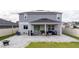 Covered patio featuring comfortable seating and a grill, perfect for outdoor entertaining in the backyard at 2984 Sanctuary Dr, Clermont, FL 34714