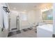 Bathroom with gray tile floor, a shower, a tub, and a vanity with a large mirror at 2984 Sanctuary Dr, Clermont, FL 34714
