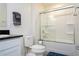 This bright bathroom features a toilet and a shower-tub combo with glass doors at 2984 Sanctuary Dr, Clermont, FL 34714