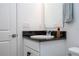 Neat bathroom featuring a white vanity with a dark granite top, and stylish decorative fixtures at 2984 Sanctuary Dr, Clermont, FL 34714