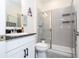 Modern bathroom showcasing a walk-in shower, sleek gray tiling, and a stylish sink with a granite countertop at 2984 Sanctuary Dr, Clermont, FL 34714