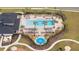 Aerial view of the community pool featuring lounge chairs, palm trees, and a splash pad at 2984 Sanctuary Dr, Clermont, FL 34714