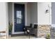 Charming front porch featuring stone accents, two chairs, and a blue front door at 2984 Sanctuary Dr, Clermont, FL 34714
