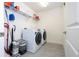 Well-lit laundry room equipped with a front-load washer and dryer and ample shelving for storage at 2984 Sanctuary Dr, Clermont, FL 34714