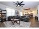 Inviting living room features a large sectional sofa, modern ceiling fan, and an open layout to the kitchen at 2984 Sanctuary Dr, Clermont, FL 34714