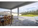 Covered patio area with stone flooring overlooking a scenic backyard with a beautiful pond view at 2984 Sanctuary Dr, Clermont, FL 34714