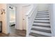 Staircase with gray wood-look treads, white risers and railings, leading to the upper level at 2984 Sanctuary Dr, Clermont, FL 34714