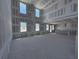 Large living room under construction showcasing natural light through windows, drywall, and open space at 30158 Rustic Mill St, Mount Dora, FL 32757