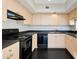 Kitchen featuring light wood cabinets and black appliances at 322 E Central Blvd # 1910, Orlando, FL 32801