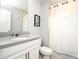 Bright bathroom with tub/shower combination, white cabinets, and a stone countertop at 3237 Palatka St, Orlando, FL 32824