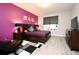 Comfortable bedroom with a purple accent wall, a large window, and a decorative rug at 3237 Palatka St, Orlando, FL 32824