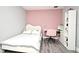Bedroom with a white-framed bed, a white desk, and an accent wall painted pink at 3237 Palatka St, Orlando, FL 32824