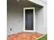 A welcoming dark front door, framed by white trim, with brick tiling and a colorful welcome mat at 3237 Palatka St, Orlando, FL 32824