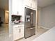 Modern kitchen features stainless steel refrigerator with water dispenser and surrounding white cabinetry at 3237 Palatka St, Orlando, FL 32824