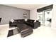 View of living room with black leather sectional sofa, ottoman, and view of outdoor pool at 3237 Palatka St, Orlando, FL 32824