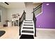 Elegant staircase with black railings and white risers stands out against the purple accent wall at 3237 Palatka St, Orlando, FL 32824