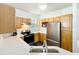 Well-lit kitchen featuring stainless steel appliances, bright quartz countertops, and wooden cabinetry at 3403 Greenwich Village Blvd # 104, Orlando, FL 32835