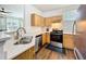 Bright and airy kitchen featuring stainless steel appliances and wooden cabinetry at 3403 Greenwich Village Blvd # 104, Orlando, FL 32835