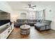 Spacious living area featuring a gray sectional sofa, ceiling fan, and a decorative center table at 3403 Greenwich Village Blvd # 104, Orlando, FL 32835