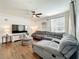 Comfortable living room with a large sectional sofa, modern ceiling fan, and bright natural light at 3403 Greenwich Village Blvd # 104, Orlando, FL 32835