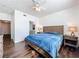 Spacious bedroom with wood floors, ceiling fan, and bright window adjacent to the main bathroom and closet at 3403 Greenwich Village Blvd # 104, Orlando, FL 32835