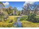 Tranquil view of a lily pond with a pathway, offering a peaceful natural setting at 3403 Greenwich Village Blvd # 104, Orlando, FL 32835