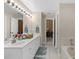 Bright bathroom featuring a double vanity, large mirror and tile flooring at 3509 S Saint Lucie Dr, Casselberry, FL 32707
