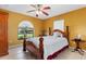 Bedroom with a wooden bed, unique window, and tile flooring at 35624 Cypress Ct, Leesburg, FL 34788
