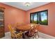Cozy dining room featuring a wooden table with seating for six and a window with picturesque water views at 35624 Cypress Ct, Leesburg, FL 34788