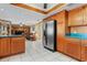 A kitchen with stainless steel appliances, wooden cabinets, and white tiled floors at 35624 Cypress Ct, Leesburg, FL 34788