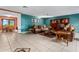 Bright living room with tile flooring, comfortable seating, built-in shelving, and large windows, creating an inviting atmosphere at 35624 Cypress Ct, Leesburg, FL 34788