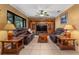 Cozy living room with tile floors, warm-toned walls, comfortable seating, and a built-in entertainment center at 35624 Cypress Ct, Leesburg, FL 34788