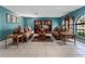 Bright living room with tile flooring, comfortable seating, built-in shelving, and large windows, creating an inviting atmosphere at 35624 Cypress Ct, Leesburg, FL 34788
