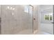 Modern walk-in shower featuring marble tile and glass doors at 4192 Barbuda Ln, Kissimmee, FL 34758