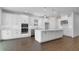 Bright, open kitchen with white cabinets, stainless steel appliances, large island, and wood-look floors at 4192 Barbuda Ln, Kissimmee, FL 34758