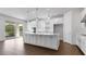 Bright, open kitchen with white cabinets, stainless steel appliances, large island, and sliding glass doors at 4192 Barbuda Ln, Kissimmee, FL 34758