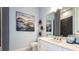 Stylish bathroom with a white vanity, modern fixtures, an elegant mirror, and a tiled shower at 4198 Barbuda Ln, Kissimmee, FL 34758
