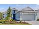 Charming home with a blue front door, attached garage, and beautifully landscaped yard at 4198 Barbuda Ln, Kissimmee, FL 34758