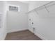 Minimalist laundry room with a wire shelf, grey wood-look tile flooring, and white walls at 4198 Barbuda Ln, Kissimmee, FL 34758
