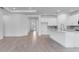 Bright, open-concept living room and kitchen with wood flooring and sleek, white cabinetry at 4198 Barbuda Ln, Kissimmee, FL 34758