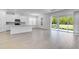 Expansive living space with light-colored flooring, modern kitchen with island, and sliding doors to the outdoor area at 4198 Barbuda Ln, Kissimmee, FL 34758